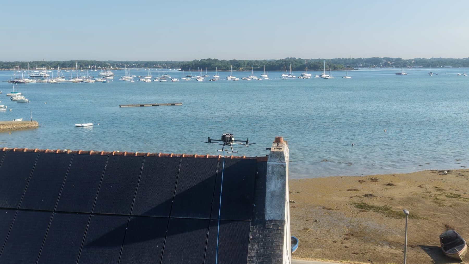 Drone ALR Drones en vol stationnaire au-dessus d'une toiture face au golfe du Morbihan