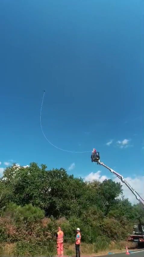 Équipes techniques en nacelle réceptionnant le filin acheminé par drone à Fégréac (44)